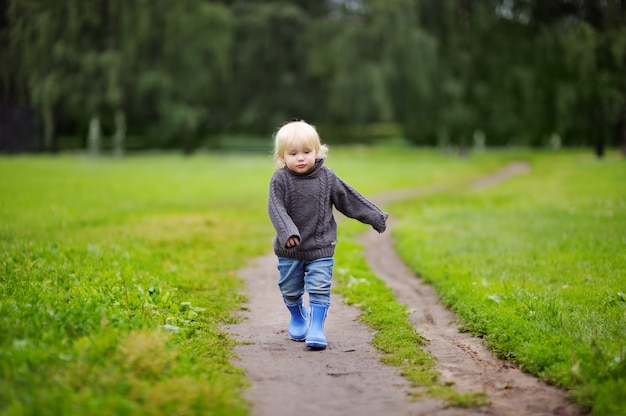 Kleinkindjunge, der am Sommer- oder Herbsttag geht