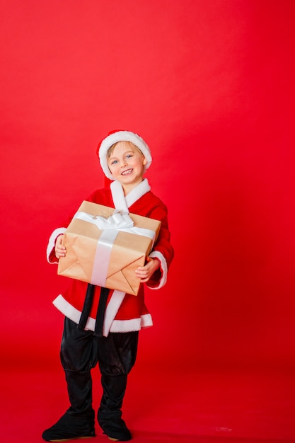 Kleinkindjunge gekleidet als Weihnachtsmann. Weihnachtseinkauf. Weihnachtsgeschenk. Kindheit
