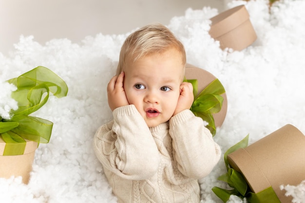 Foto kleinkindjunge im weihnachtsinnenraum weihnachtsinnenarchitektur eines gemütlichen bettes im schlafzimmer verziert