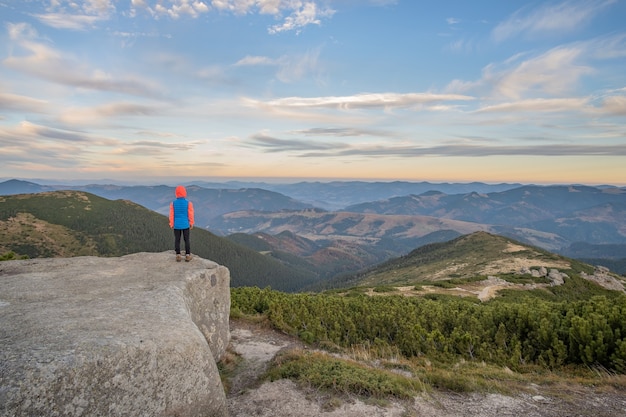 Kleinkindjungenwanderer, der in den Bergen steht, die Ansicht der erstaunlichen Berglandschaft genießen.