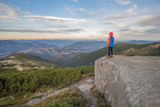 Kleinkindjungenwanderer, der in den Bergen steht, die Ansicht der erstaunlichen Berglandschaft genießen.