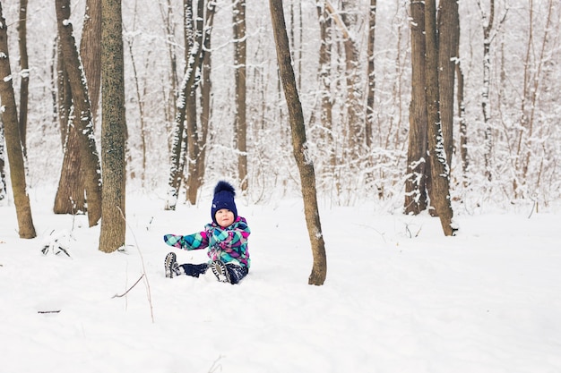 Kleinkindkind, das im Winter im Schnee spielt.