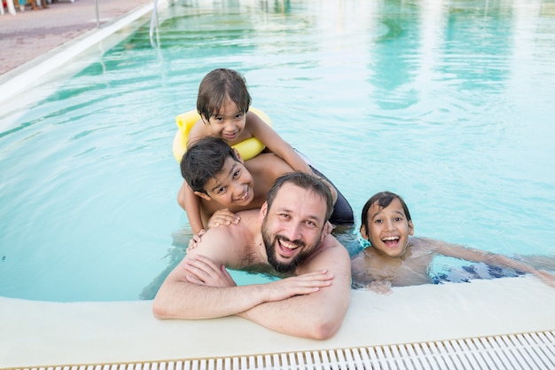 Kleinkindkinderkind, das im Swimmingpool hat Spaßfreizeitaktivität spritzt