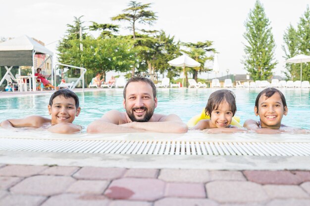 Kleinkindkinderkind, das im Swimmingpool hat Spaßfreizeitaktivität spritzt