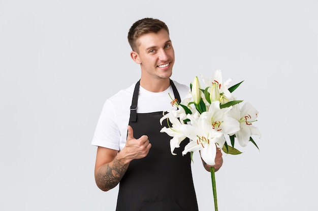 Kleinunternehmen Einzelhandel und Mitarbeiter Konzept hübscher Verkäufer in schwarzer Schürze machte schöne Blumen ...