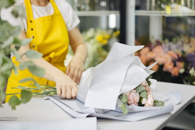 Kleinunternehmen. Florist unkonzentriert im Blumenladen. Blumendesignstudio, Blumenstrauß machen. Blumenlieferung, Auftragsseitenansicht erstellen