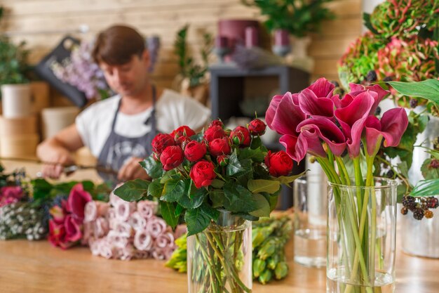 Kleinunternehmen. Männlicher Florist unkonzentriert im Blumenladen. Blumen-Design-Studio, Dekorationen und Arrangements. Blumenlieferung, Bestellung erstellen