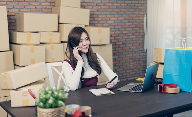 Kleinunternehmen Startup Unternehmer KMU oder freiberufliche Frau arbeiten mit Boxen zu Hause oder im Büro. Umgang mit Lieferpaketen