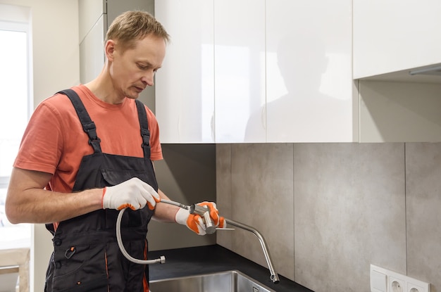 Klempner installiert einen Wasserhahn an der Küchenspüle