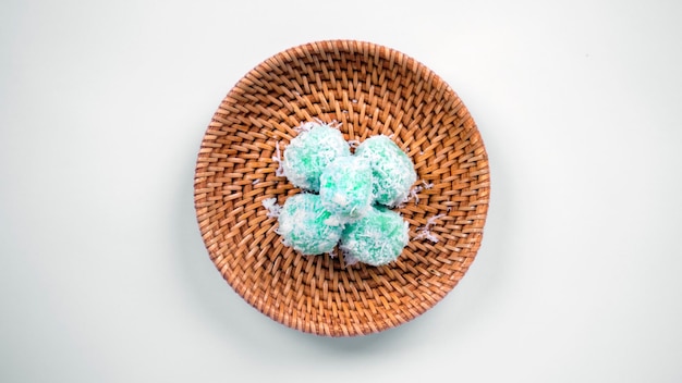 Klepon ou bolinhos de arroz pegajoso verde recheados com açúcar de palma líquido e cobertos com coco ralado