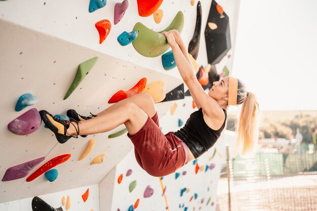 Foto kletterer mit kletterausrüstung klettern an einer felswand im freien xtreme-sport- und boulderkonzept kletterer klettert an einer felswand