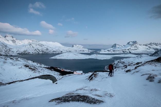 Kletterer verloren auf schneebedeckten Bergen mit Himmel am arktischen Ozean in der Abenddämmerung