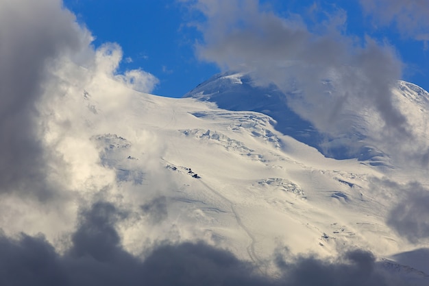 Klettersteig auf dem östlichen Gipfel des Mount Elbrus, der Hang mit Schnee ist durch die Wolken sichtbar. Gebirgszug im Nordkaukasus in Russland.