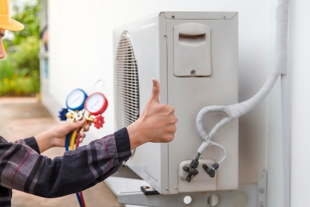 Klimaanlagentechniker repariert zentrale Klimaanlage mit Outdoor-Werkzeugen.