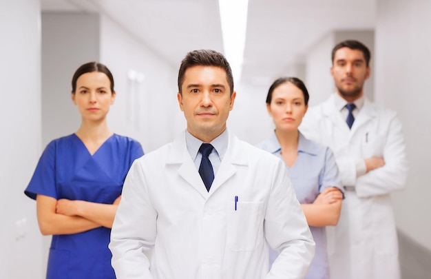 klinik, beruf, menschen, gesundheitsversorgung und medizinkonzept - gruppe von medizinern oder ärzten im krankenhauskorridor