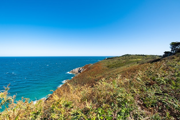 Klippe nahe ruhigem Meer am sonnigen Tag