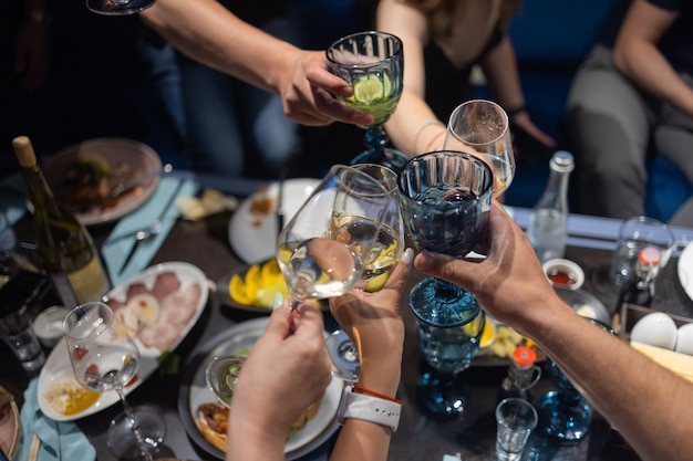 Klirrende Gläser mit Alkohol und Toasten, Party.