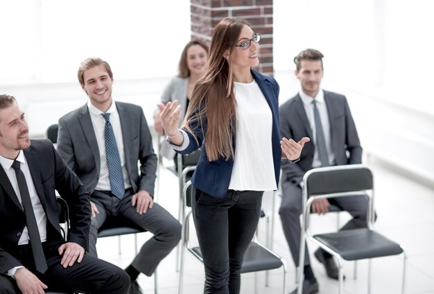 Kluge Geschäftsfrau, die beim Seminar mit ihren Kollegen in der Nähe Fragen stellt