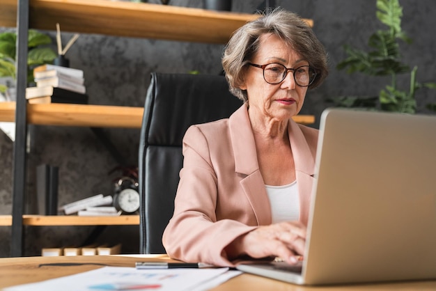 Kluge kaukasische Geschäftsführerin, leitende Geschäftsfrau, die Laptop für Remote-Arbeit benutzt, freiberufliche E-Banking-Job