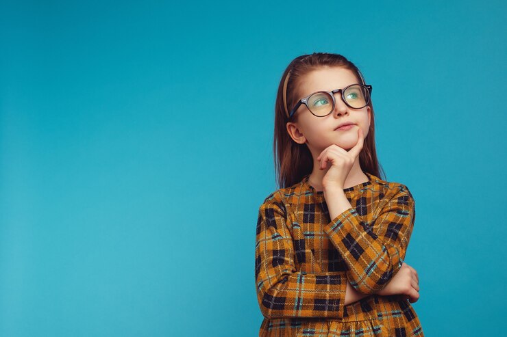 Kluges Mädchen in nerdiger Brille, das die Wange berührt und beim Denken aufschaut