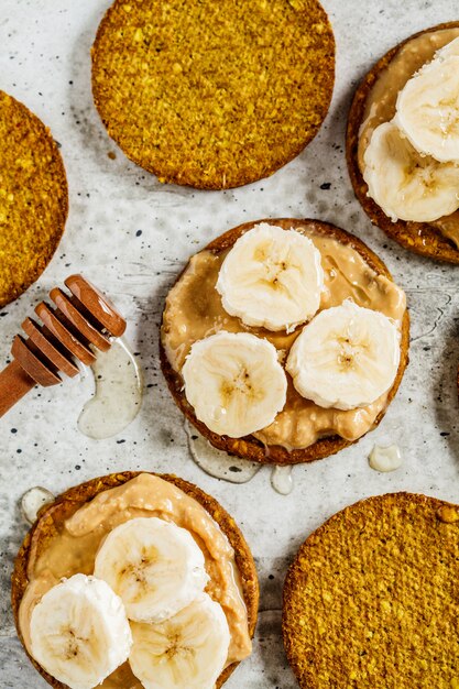 Knäckebrot mit Erdnussbutter, Banane und Honig, Draufsicht. Veganes Lebensmittelkonzept.