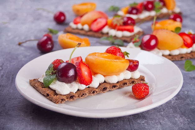 Knäckebrot mit Frischkäse, Obst und Beeren