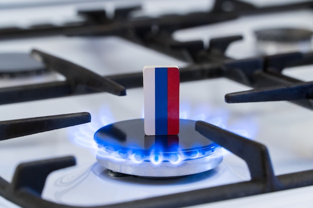 Knappheit und Gaskrise. Flagge der Russen auf einem brennenden Gasherd