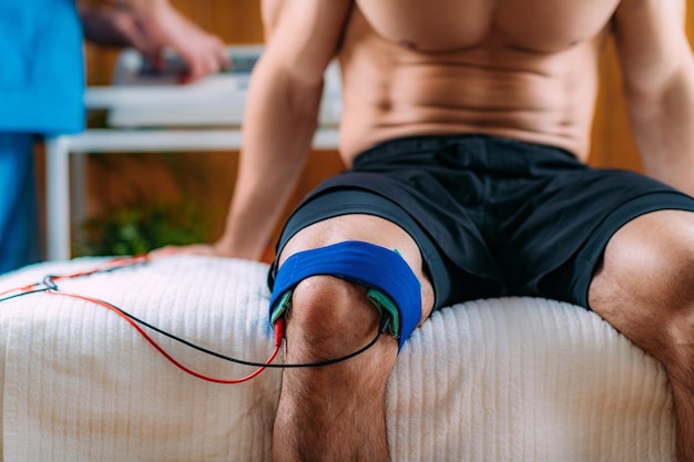 Foto knie-physiotherapie mit tens-elektroden-klammern-pads transkutane elektrische nervenstimulation