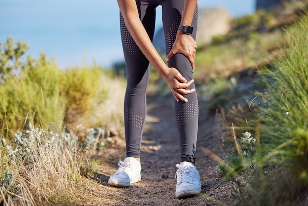 Foto knieschmerzen, laufverletzung und fitness einer frau beim outdoor-training und medizinischer notfall mit den händen an den beinen. gesundheitsunfall beim laufen und sportlerin mit entzündung und gelenkschmerzen