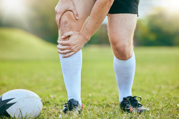 Foto knieschmerzen, rugby-beine und sportler, müde, müde, schmerzend, trainingsunfall, spiel oder herausforderung auf dem rasen, körperqualen, anatomie des sportlers oder nahaufnahme eines spielers mit risiko für einen medizinischen notfall