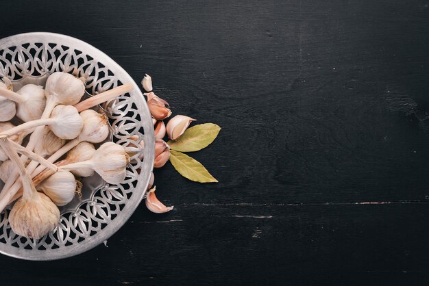 Knoblauch auf einem Teller Frischer Knoblauch auf einem hölzernen Hintergrund Ansicht von oben Kopieren Sie Platz