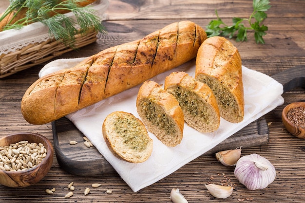 Foto knoblauch-baguette-rolle auf einem holzschneidebrett