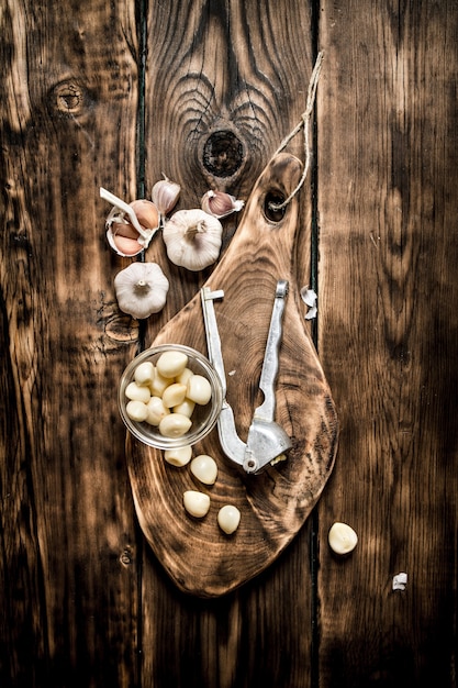 Foto knoblauch hintergrund. frischer knoblauch auf altem holzbrett. auf hölzernem hintergrund