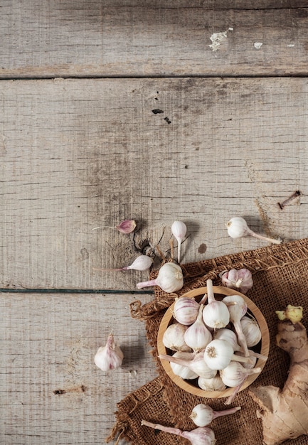 Knoblauch in den Schüsseln auf Bretterboden.