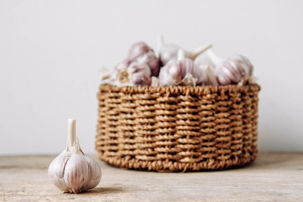 Knoblauch in einem Weidenkorb auf einem Holztischhintergrund Kopieren Sie leeren Platz für Text