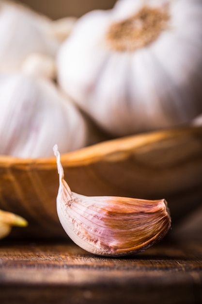 Knoblauch. Knoblauchzehen und Knoblauchknolle in Vintage-Holzschale.