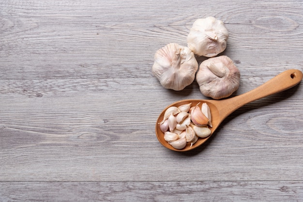 Knoblauch mit hölzernem Löffel auf Tabelle