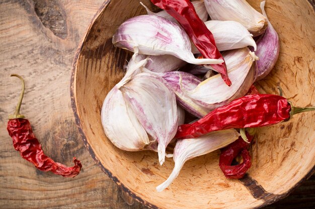 Knoblauch mit rotem Chilipfeffer auf hölzernem Hintergrund.