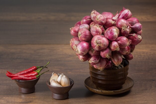 Knoblauch Schalotten Chilli auf Holztisch.