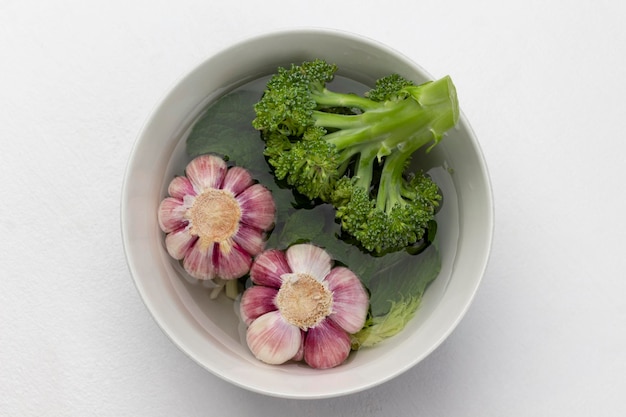 Knoblauch und Brokkoli in einer Schüssel mit Wasser Lebensmittel-Stillleben