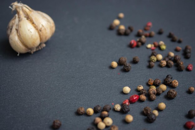 Knoblauch und Pfeffermischung auf schwarzer Tafel mit Kopierplatz Knoblauchzwiebel und bunte Pfefferkornen