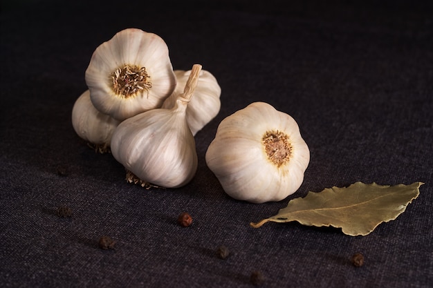 Foto knoblauch, zwiebel, lorbeerblatt, schwarzer pfeffer auf textil