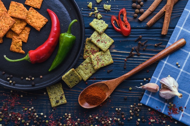 Knoblauchpfefferpaprika auf einem hölzernen Löffel und Gewürzen