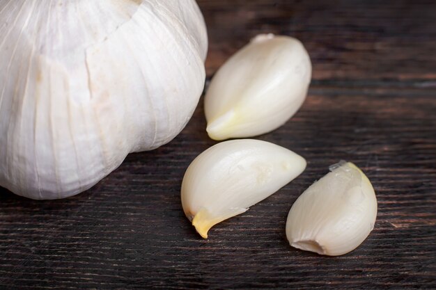 Knoblauchzehen und Kopf Nahaufnahme auf einem hölzernen Hintergrund Nahaufnahme Makro-Shooting