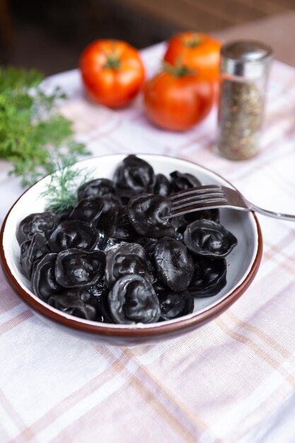 Knödel mit Gewürzen und Kräutern in einer schwarzen Platte auf Steinhintergrund Traditionelle russische Gericht Knödel