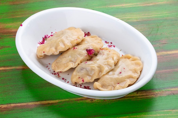 Knödel mit Kirschen auf einem farbigen Hintergrund aus Holz Vegetarisches Gericht