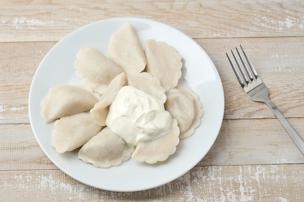 Knödel mit saurer Sahne auf einem Teller