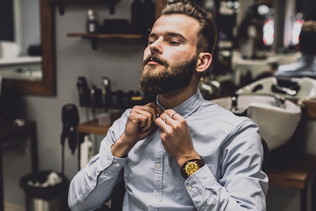 Foto knöpfendes hemd des mannes im friseursalon