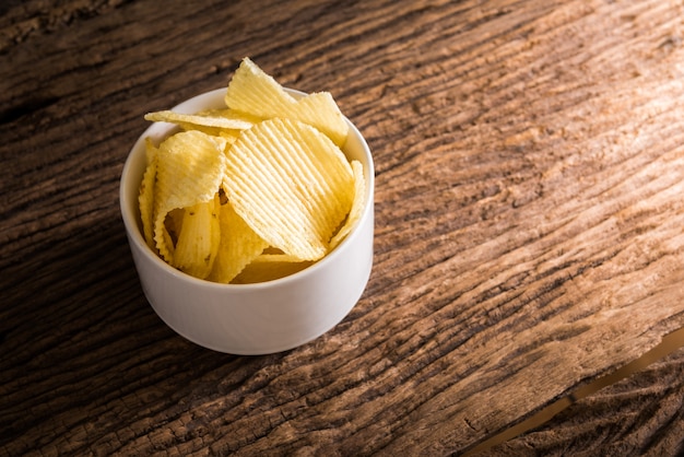 Knusperige Kartoffelchips auf Holztischhintergrund