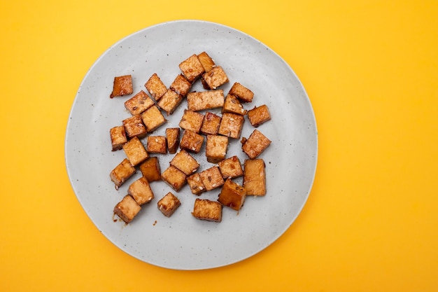 Knusprig frittierte Tofuwürfel auf kleinem Teller
